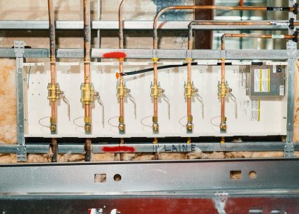 Panneau de distribution de gaz médicaux en cours d’installation, avec tuyauterie en cuivre, vannes de régulation et isolation murale visible