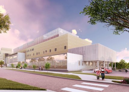 Vue extérieure de l’Hôpital Fleurimont à Sherbrooke, montrant une architecture contemporaine en briques blondes et panneaux métalliques, avec une entrée vitrée et des passants sur le trottoir