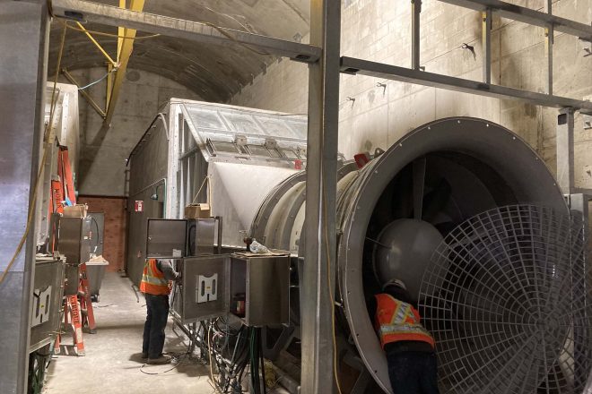 Technicians performing maintenance on an industrial ventilation system in a STM tunnel at Côte-Vertu