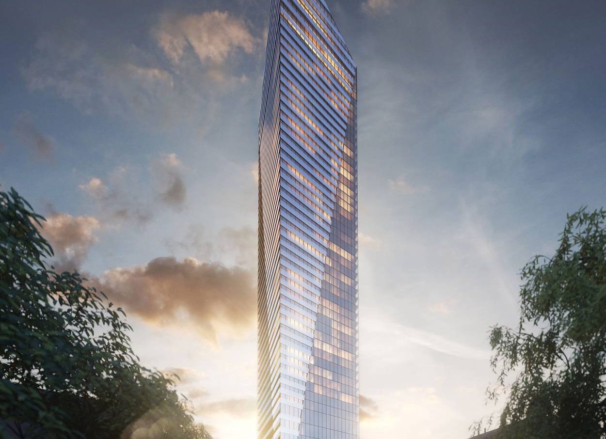 Vue au crépuscule de la Tour Victoria sur le Parc à Montréal, mettant en valeur son architecture élancée en verre et sa silhouette triangulaire distinctive dans le centre-ville