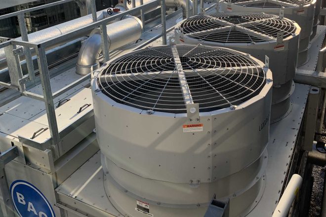 Tours de refroidissement BAC installées sur le toit d’un immeuble à Victoria sur le Parc, avec conduits de ventilation industrielle en arrière-plan